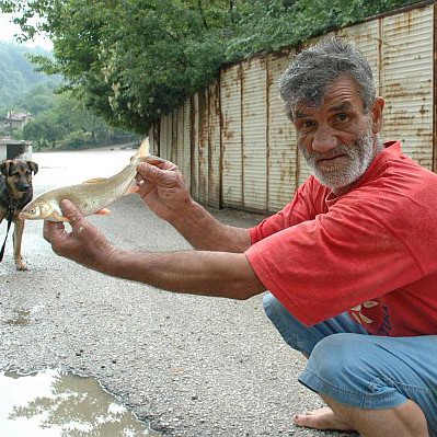 Жител на Търново показва изхвърлената на брега риба