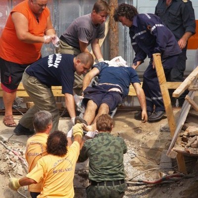 Изваждането на раненият работник от изкопа, след рухването на стената на съседна сграда