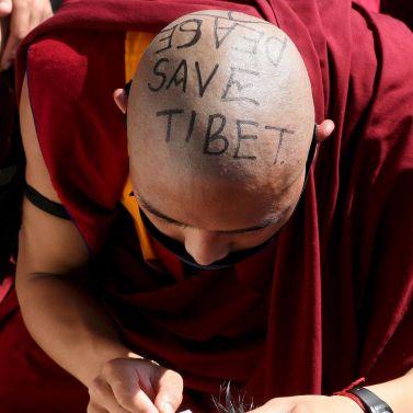 Тибетски монах с изписан лозунг на главата