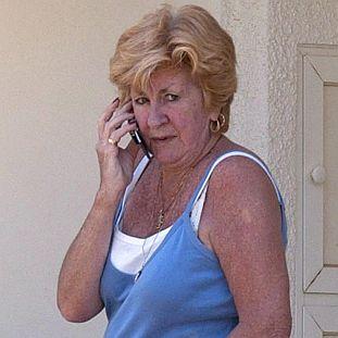 Възрастна жена говори по телефона