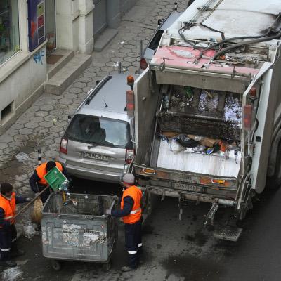 Работници от фирма за чистота събират боклука от контейнерите за смет по обяд, затруднявайки трафика па столичните улици