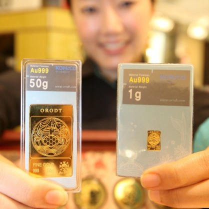 Служителка в магазин в Сеул показва златни барчета