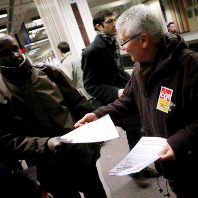 Стачкуващ работник от френските железници раздава разяснителни брошури