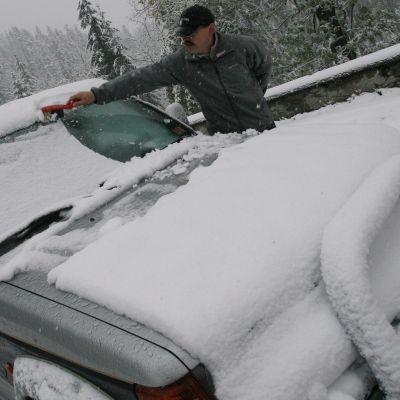 Шофьор чисти колата си от сняг