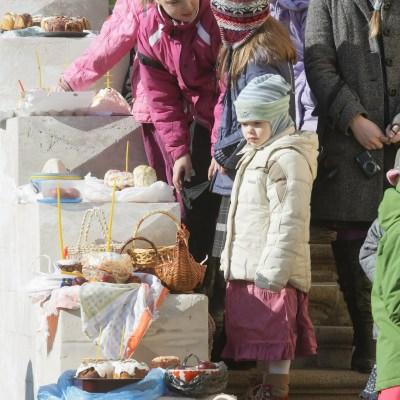 Руски деца стоят на стълбите на църква в очакване на свещеник да освети козунаци и яйцата им за Великден в Москва