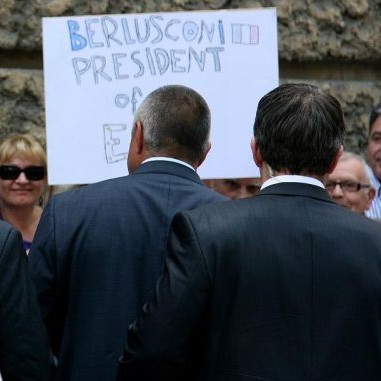 Мъж с плакат  Берлускони президент на ЕС  посрещна италианския премиер