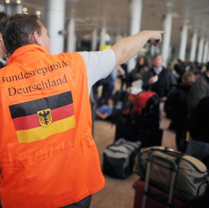 Мъж от германското посолство в Египет придружава група от около 150 германци на летището в Кайро