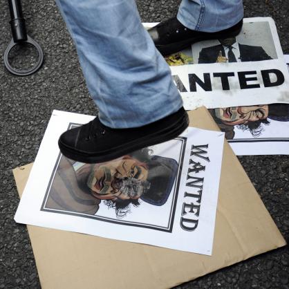 Демонстратор стъпква карикатура на Кадафи на митинг пред либийското посолство в Токио