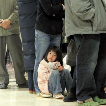 Момиченце чака на опашка за храна в Япония