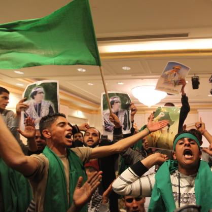 Поддръжници на либийския лидер Муамар Кадафи песнопение антиамерикански лозунги по време на митинг в хотела, където са настанени журналисти в Триполи