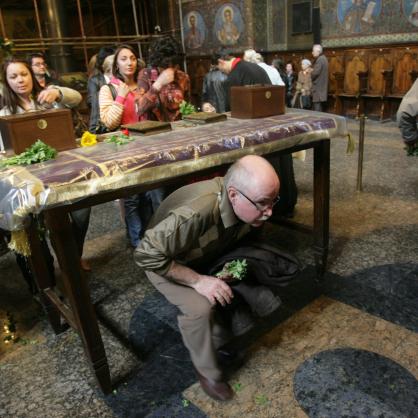 Вярващите на Разпети петък ходят на църква, минават три пъти под масата за здраве, излизат и целуват разпятието