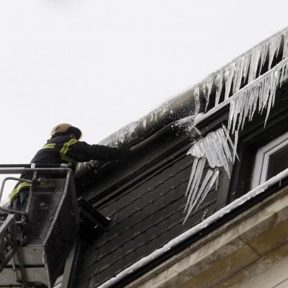 Екипи на пожарната премахват ледени висулки от сграда в центъра на София