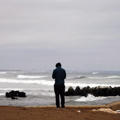 Йошихиро Мори се моли на брега на океана за свой приятел