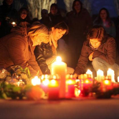 Жени палят свещи в памет на загиналите при катастрофата в тунел в Швейцария