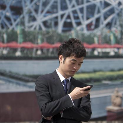 Китаец проверява за съобщения смартфона си
