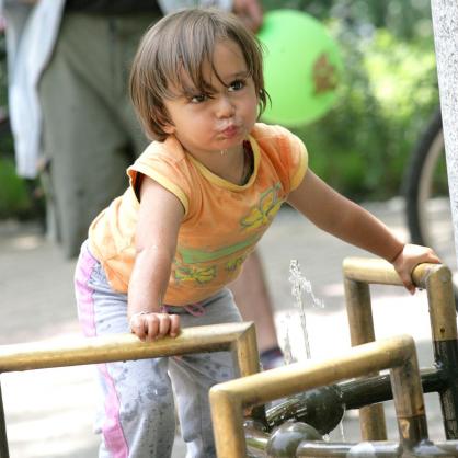 Дете пие вода на чешма в парка