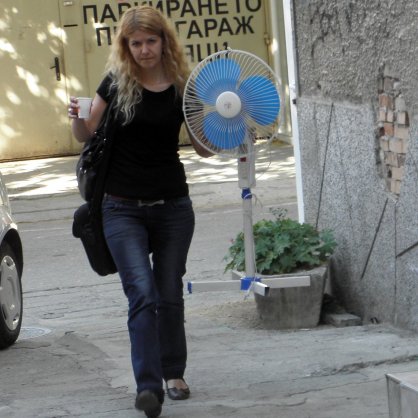 34-градусова жега - жена носи вентилатор