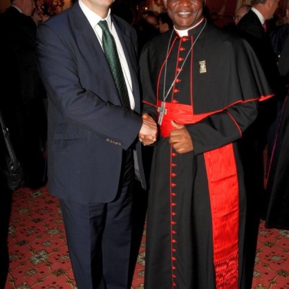 Бившият британски министър на енергетиката Крис Хюн и кардинал Питър Турксон от Гана