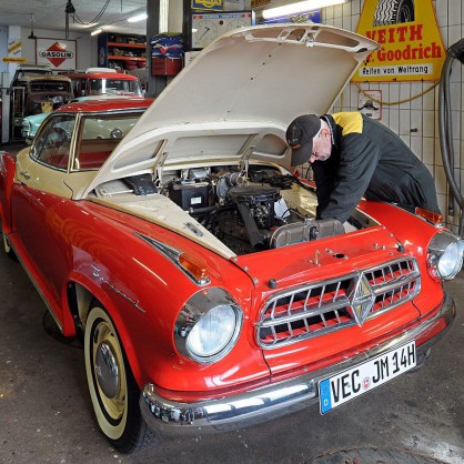 Монтьор поправя Borgward Isabella от 1959 година в автосервиз за ретро коли в Германия