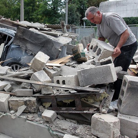 Мъж претърсва развали в покрайнините на Донецк