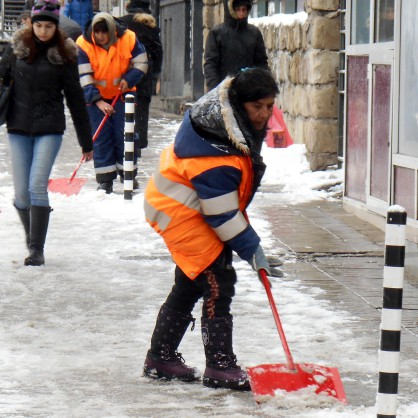 Служители почистват тротоарите на спирките