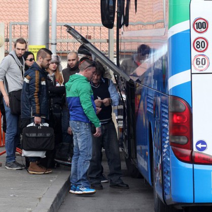 Пътници качват багажа си в автобус