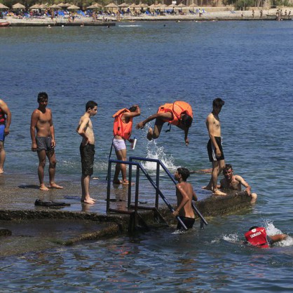 Мигранти се радват на слънцето и морето по гръцките плажове